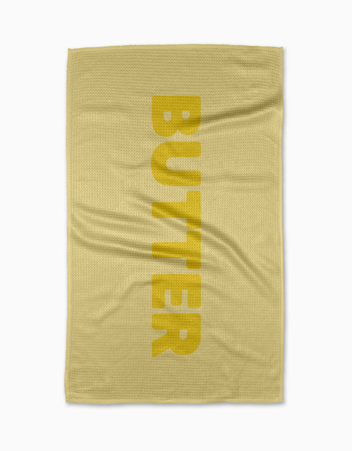 The GEOMETRY Butter yellow tea towel is made from Geoweave fabric, printed vertically with BUTTER in bold yellow letters and featuring a subtle textured pattern, shown laid flat on a white background.