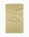 A rectangular yellow GEOMETRY Buttermilk tea towel made from recycled materials features a small white geometric pattern and is shown flat on a white background with slight wrinkles.