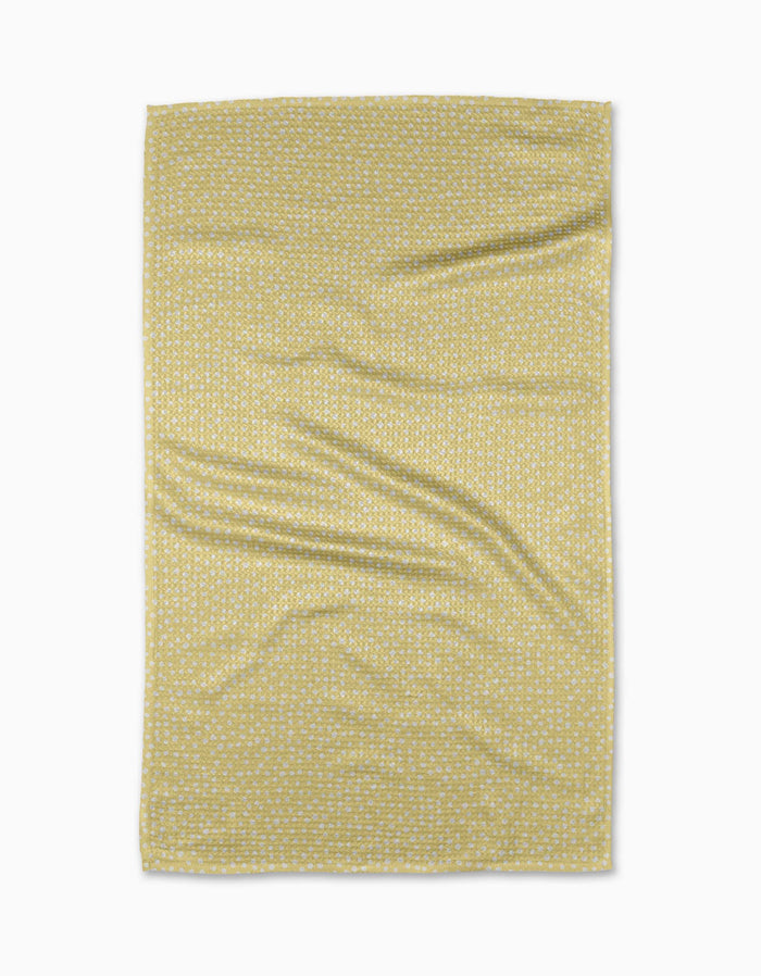 A rectangular yellow GEOMETRY Buttermilk tea towel made from recycled materials features a small white geometric pattern and is shown flat on a white background with slight wrinkles.