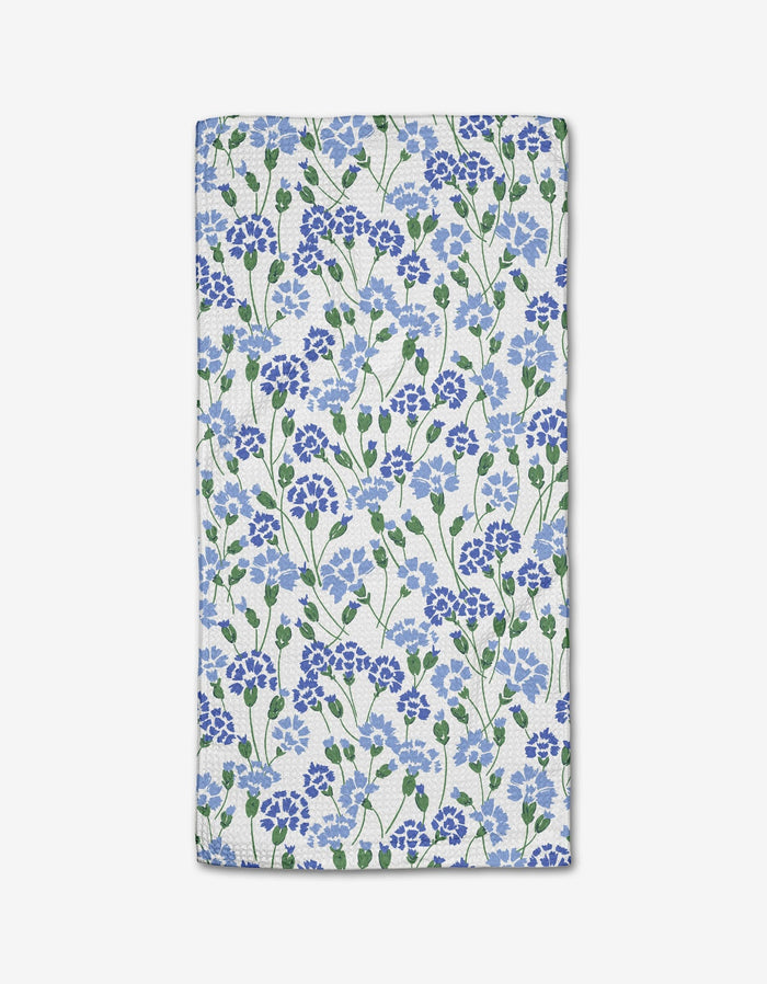 The Carnation Fields Bar Towel by Hufton Studio features a dense blue and purple floral pattern with green leaves on white Geoweave fabric.