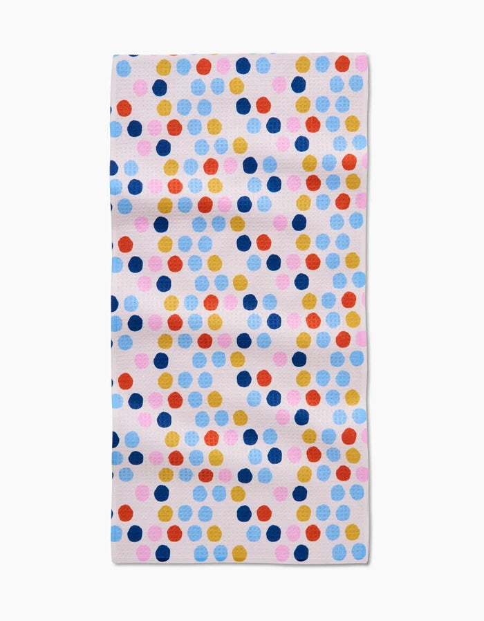 The Lizzie Clark Carnival Bar Towel features a white background with evenly spaced colorful polka dots in blue, pink, yellow, red, and orange. Made of soft Geoweave fabric for extra absorbency.