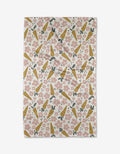 The Carrot Patch tea towel by Charlie Rowan Designs features a diagonal pattern of yellow carrots, pink flowers, and green leaves on white—a delightful kitchen accent.