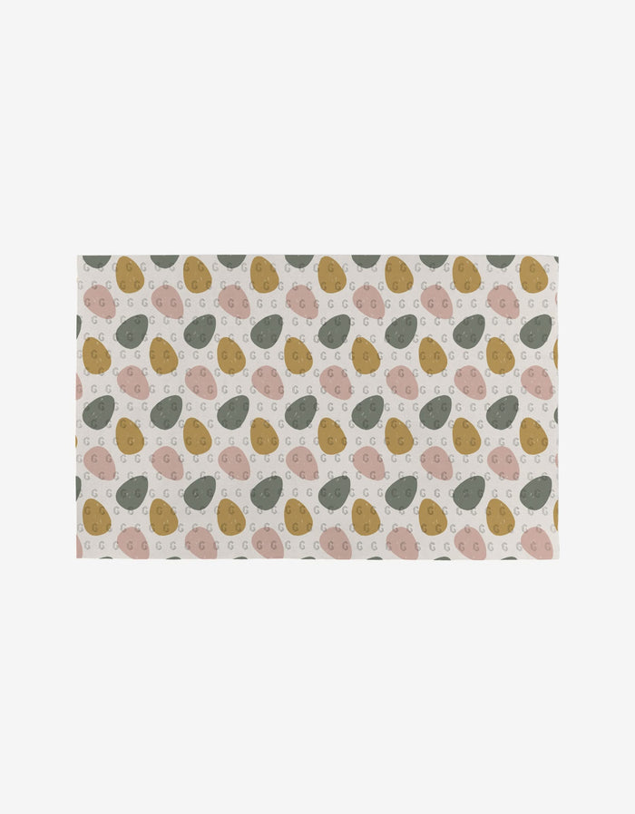 The Carrot Patch rug by Charlie Rowan Designs is a rectangular, reusable piece featuring abstract ovals in muted pink, green, mustard yellow, and beige on a light background—an eco-friendly option for stylish spaces.