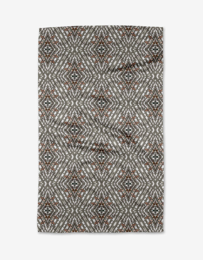The Katherine Berkeley Cha Cha Interchange tea towel features a geometric diamond pattern in gray, white, black, and rust tones, creating a symmetrical kaleidoscope-like design on this quick-drying rectangular towel.