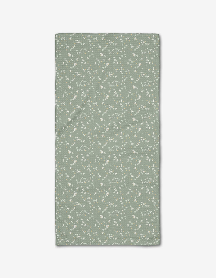 The Chamomille Terrazzo Bar Towel by Second Nature Studio is rectangular, light green Geoweave fabric with a subtle white floral pattern, shown laid flat on a white background.