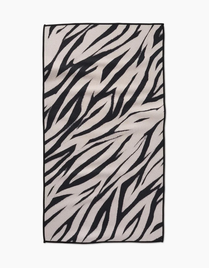 The Chase rug by GEOMETRY features a rectangular shape with bold, irregular black zebra stripes on a light background and is crafted from recycled materials.