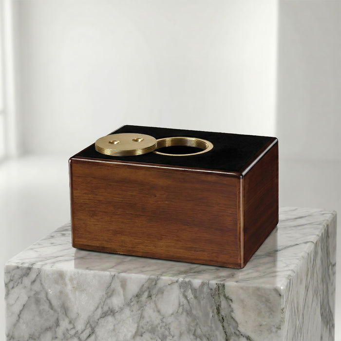 Wooden and brass box on a marble surface with a white background
