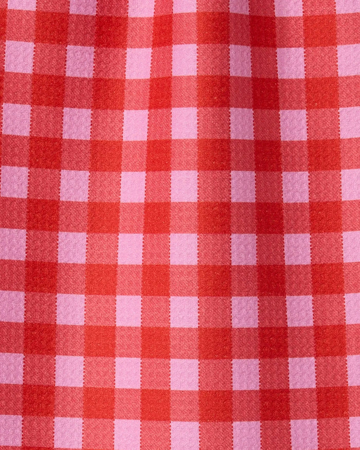 Close-up of Cherry Gingham by GEOMETRY, featuring a red and pink checkered pattern with visible texture, crafted from recycled materials and highlighted by fabric folds.