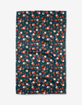 The Cherry Love tea towel by Charlie Rowan Designs features a playful pattern of red and white cherries with green stems on a dark Geoweave fabric background, arranged randomly across its rectangular surface.
