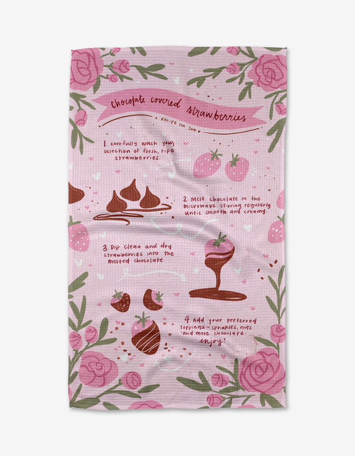 The Chocolate Covered Strawberries tea towel by Janna Sue Design is pink and floral, made from recycled materials, and features illustrated, step-by-step chocolate strawberry instructions on a patterned background.