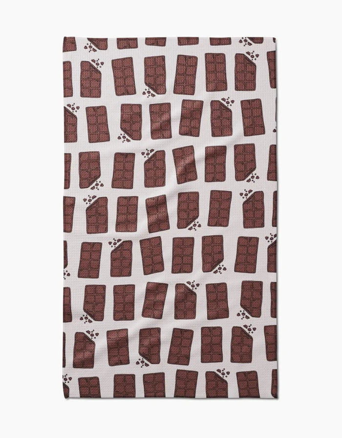 The Chocolate Everything tea towel by Amy Droubay features a white Geoweave fabric with a repeating pattern of illustrated chocolate bars and scattered brown paw prints.