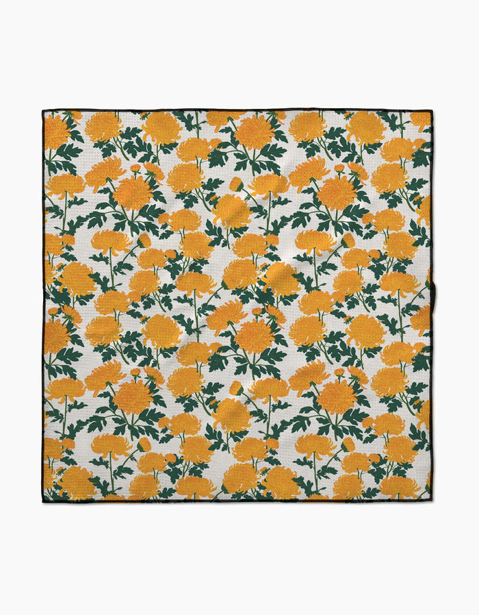 The Vaishali Design Studio Chrysanthemum is a square cloth made from recycled materials, featuring vibrant yellow marigolds with green stems on white. Highly absorbent and perfect for use as dog towels or for everyday cleanup.