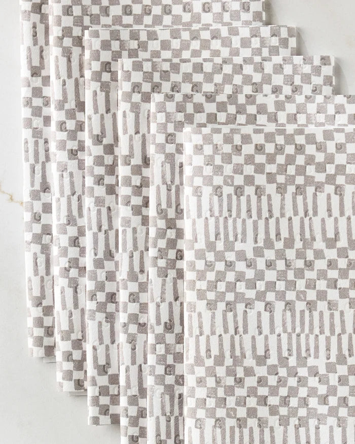 Four folded Chutes Coffee kitchen towels from Studio Jeannot, featuring an eco-friendly geometric beige and white checkered pattern, fanned out on a light surface.