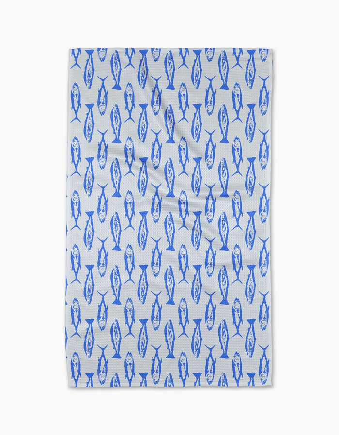 The Geometry Coastal Catch Tea Towel, made from Geoweave fabric, features a repeating blue fish pattern and is shown flat against a plain white background.