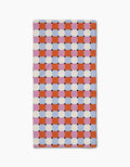 The Claire Iglesias Color Block Grid Bar Towel is crafted from Geoweave™ fabric and showcases an orange, pink, and white checkerboard pattern with blue and black accents on a crisp white background.