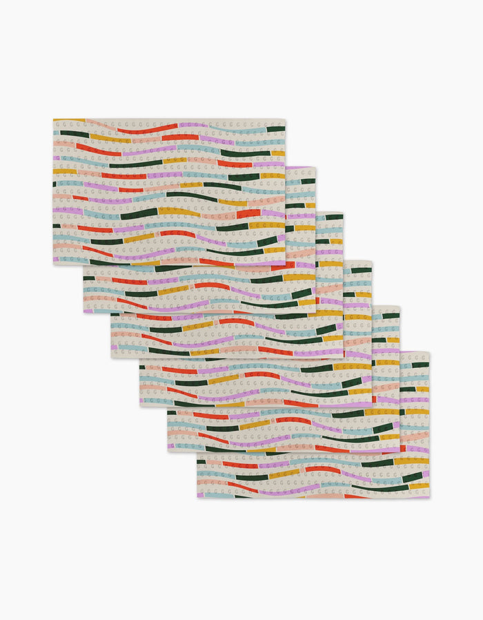 Six Colorful Currents rectangular placemats by Geometry feature wavy green, yellow, red, orange, and pink stripes on a light background—made from eco-friendly post-consumer recycled materials and arranged in a fanned-out stack.