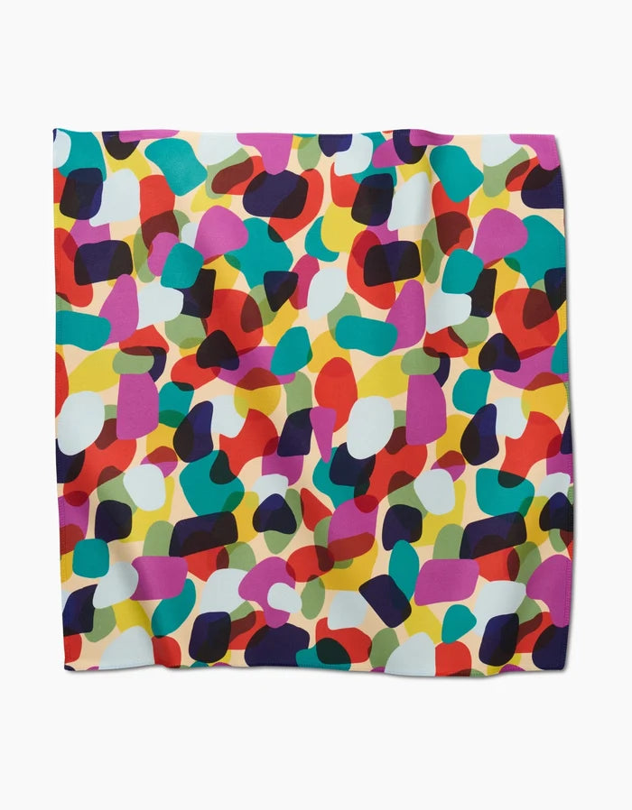 The GEOMETRY Colorful Pebbles square scarf is made from Geosuede and showcases an abstract design with overlapping red, blue, yellow, green, purple, and white shapes set against a light background.