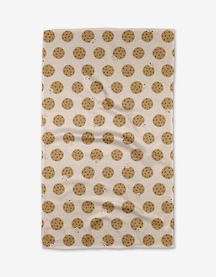 The Purely Kaylie Cookie Crumble tea towel, crafted from Geoweave fabric, showcases an all-over chocolate chip cookie pattern and is displayed flat.