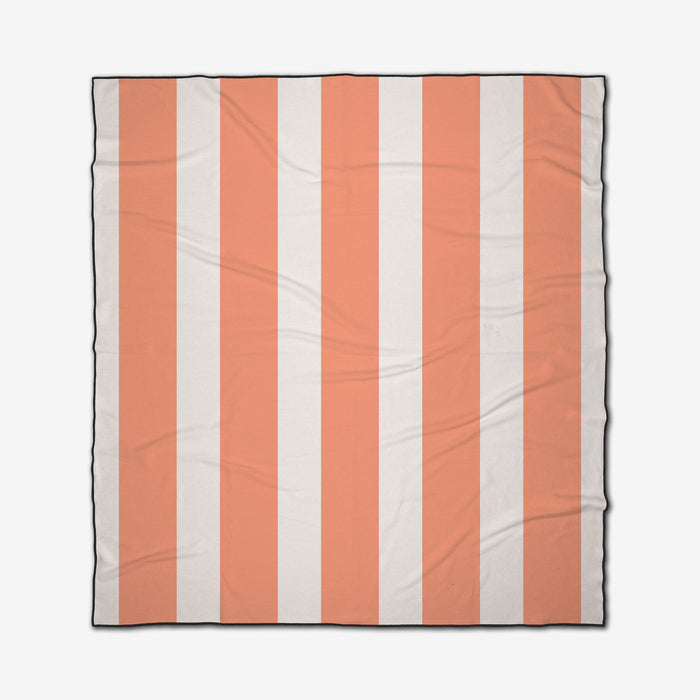 The GEOMETRY Coral Block Stripes is a square, quick-drying beach blanket with light orange and white vertical stripes, a thin black border, and a slightly wrinkled fabric appearance.