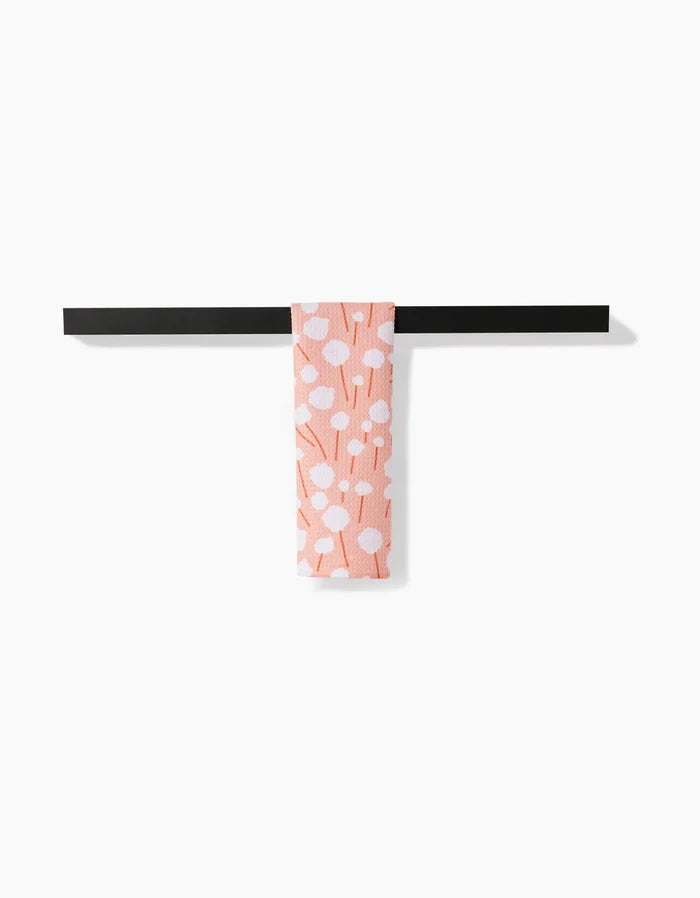 The Cotton Floral bar towel by Coit Creative, featuring white polka dots and branch patterns on pink Geoweave fabric, is draped over a black towel bar against a plain white background.