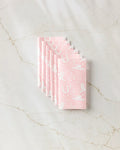 Six Cowgirl Chic reusable paper towels by Aubrey Fairchild are neatly stacked on a white marble surface, featuring pink and white western-themed patterns like boots, hats, cacti, and horseshoes.
