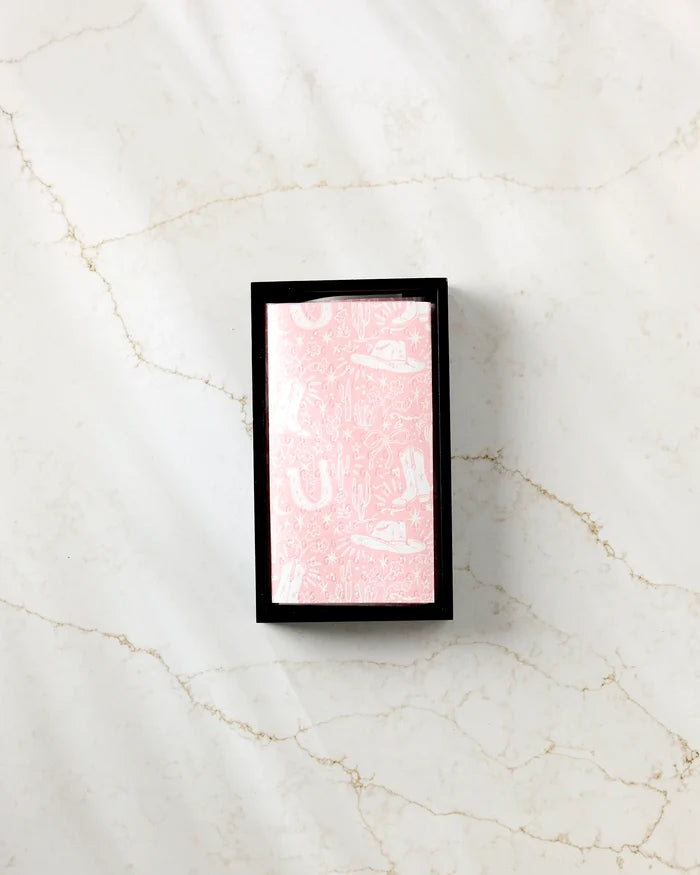 Aubrey Fairchild’s Cowgirl Chic deck features pink and white patterned backs and comes neatly packaged in a black box, displayed on a white marble surface.
