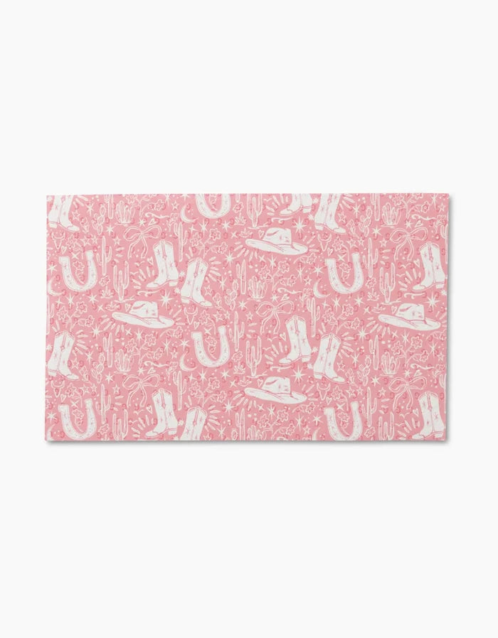 Cowgirl Chic by Aubrey Fairchild is a pink rectangular mat with a white Western print of boots, hats, horseshoes, cacti, and stars. Reusable and eco-friendly—an ideal Not Paper Towels alternative.