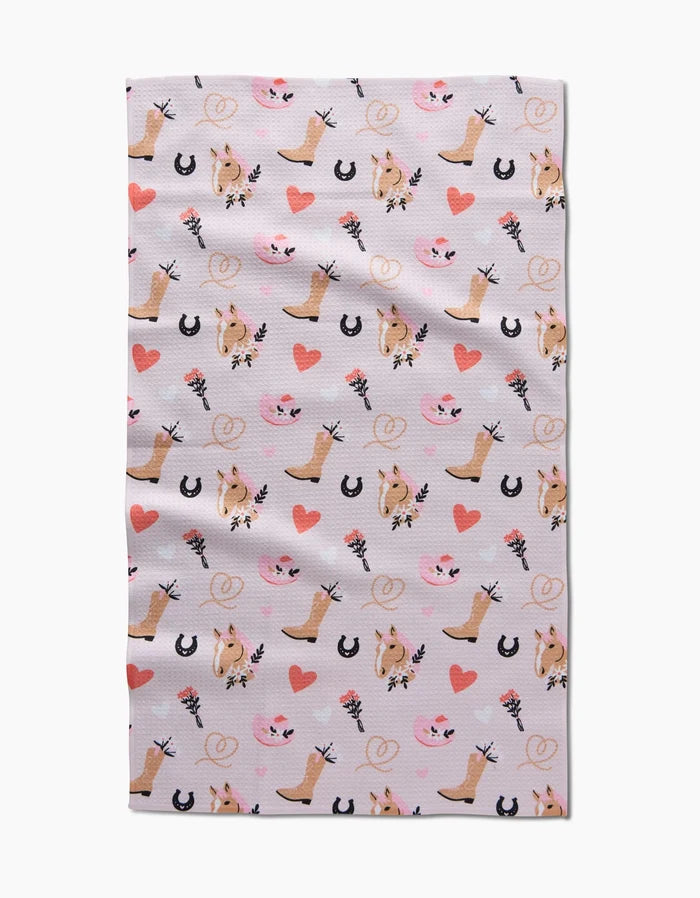 Cowgirl Love by Amberleigh Adoff: A repeating pattern of cowboy boots, horses, hearts, and lassos in pink, brown, and black on light—ideal for an eco-friendly, ultra-absorbent kitchen or tea towel.