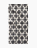 The Cross Hatch bar towel by Rosa Kichline features black and white overlapping grid-like squares on Geoweave fabric, shown flat against a white background.