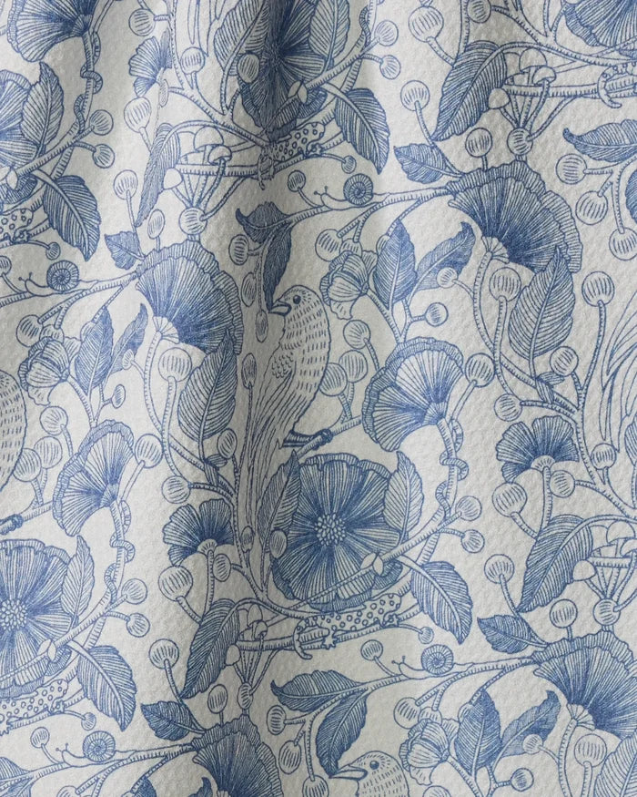 The Katie O'Shea "Crowberries" tea towel features blue and white hand-drawn botanical patterns with flowers, leaves, berries, and birds on gently pleated fabric—adding charm and texture to any kitchen.