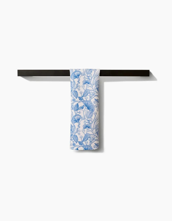 The Crowberries bar towel by Katie OShea, featuring a blue floral pattern on white Geoweave fabric, is neatly folded over a sleek black towel bar against a plain white background.