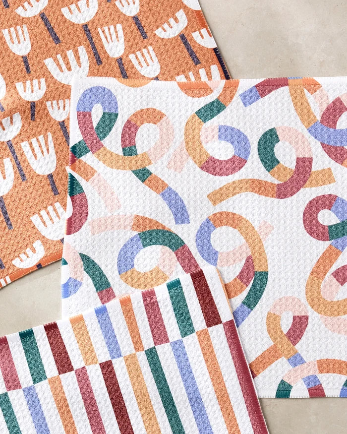 The Claire Iglesias Cutout Shapes dishcloth set includes three super-absorbent towels, each with a unique design, made from recycled materials for an eco-friendly addition to your kitchen.