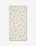 The Hufton Studio “Daisy Dust” Bar Towel is crafted from cream-colored Geoweave fabric with a textured surface and features a scattered yellow daisy pattern with green stems and leaves on a white background.