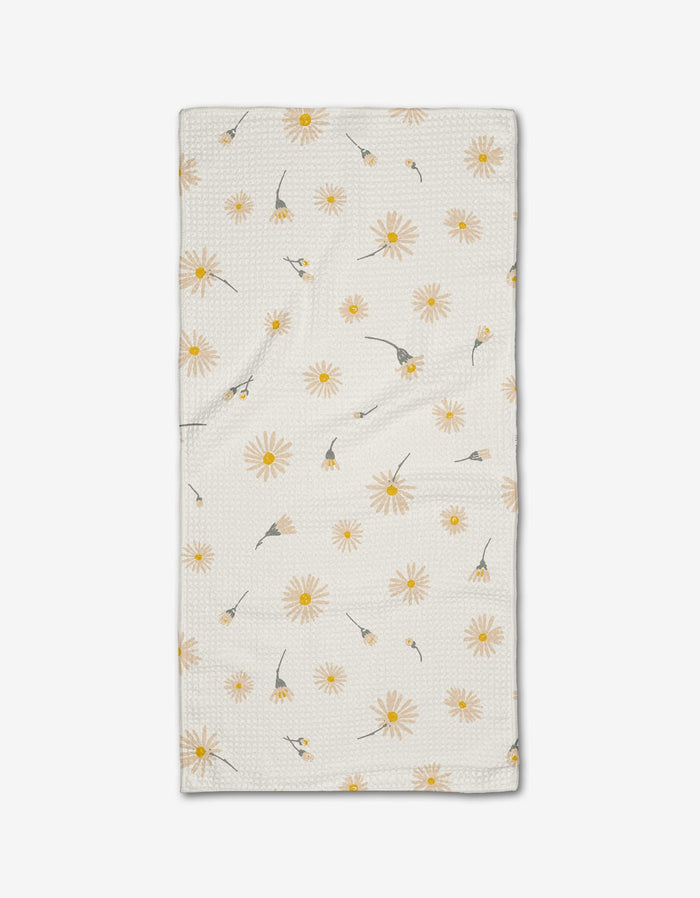 The Hufton Studio “Daisy Dust” Bar Towel is crafted from cream-colored Geoweave fabric with a textured surface and features a scattered yellow daisy pattern with green stems and leaves on a white background.