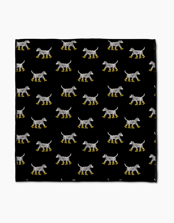 Dalmatian In Boots Black by Geometry features rows of spotted dogs in yellow rain boots on a black background. Printed on ultra-absorbent Geoweave fabric, this Paw Towel blends playful style with practical functionality.