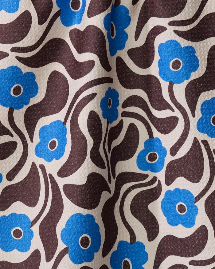 Dancing Blooms by Gerdadzy features a seamless retro floral pattern with blue flowers and brown shapes on textured cream. This bold, mid-century modern tea towel is made from quick-drying, recycled materials.