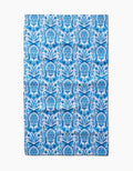 The Sarah Daugherty Delft Blue Easter Egg Damask tea towel features a repeating blue floral and fruit vase pattern with symmetrical, intricate detailing on a white background.