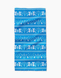 The Delft Blue Easter Stripe by Sarah Daugherty is a Geoweave napkin with blue horizontal stripes and white silhouettes of rabbits, Easter eggs, flowers, and leaves in a repeating pattern.