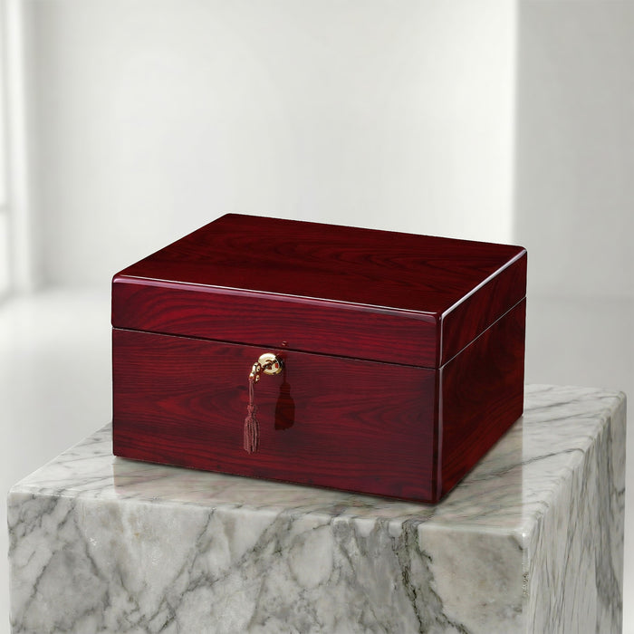 Red wooden jewelry box with a gold clasp on a marble surface