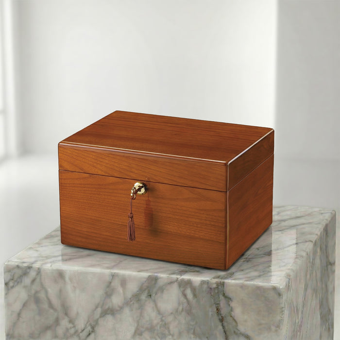 Wooden urn box with a gold clasp on a marble surface