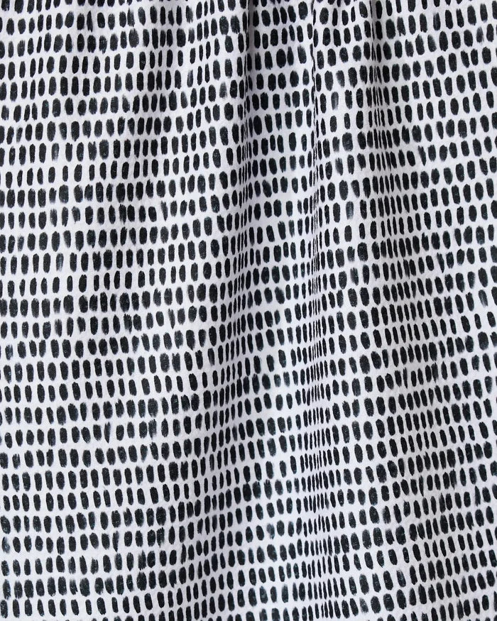 Close-up of Geometry’s Dot Dot Dot Fresh Linen kitchen towel, featuring a grid-like pattern of irregular black dots on white recycled fabric with a lightly gathered, textured look.