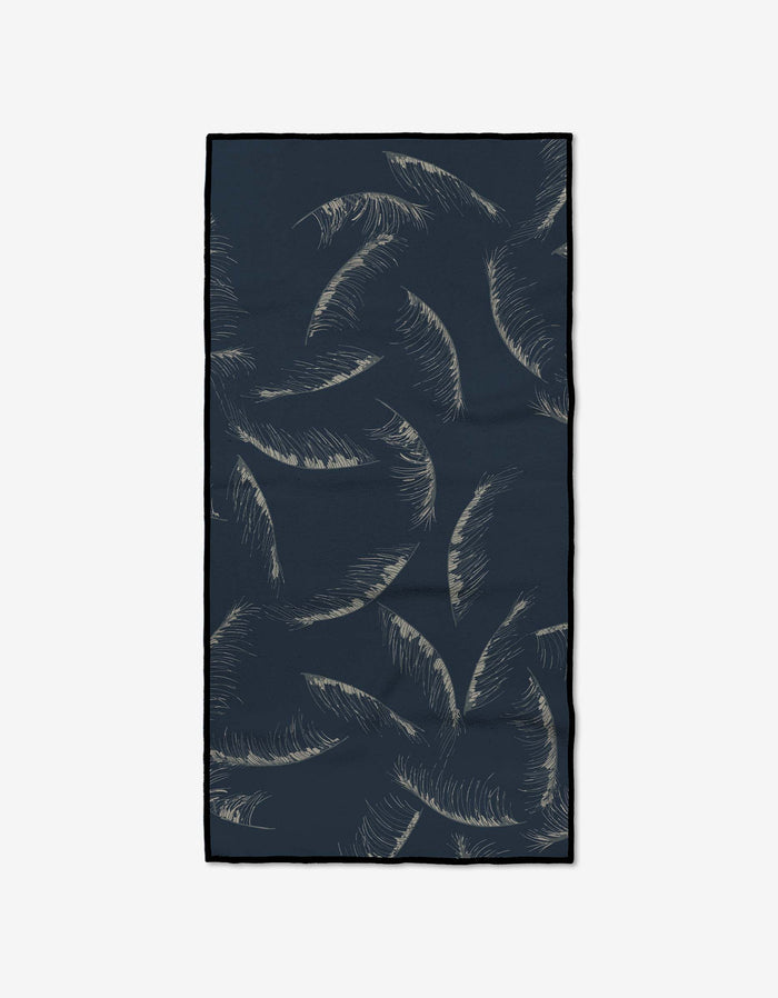 The GEOMETRY Due North Midnight Fitness Towel is rectangular and dark blue with beige palm leaves. Made from ultra-absorbent Geoweave fabric, it features a minimalistic design and black-outlined edges.