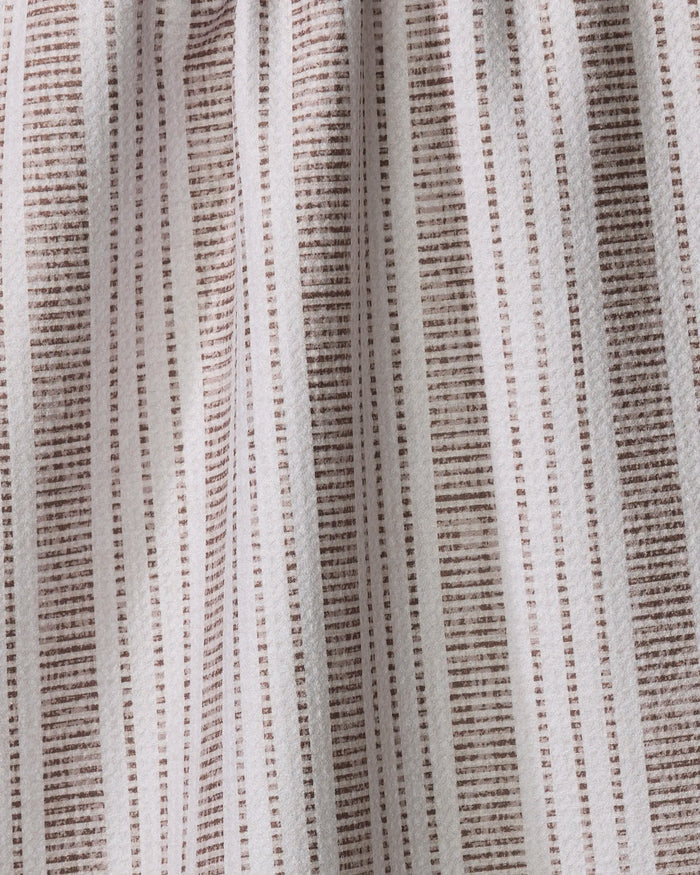 Close-up of the Dyer Rust tea towel by Becki Owens, featuring evenly spaced vertical brown stripes and small horizontal dashes for a textured, grid-like look. The ultra-absorbent fabric appears gently pleated.
