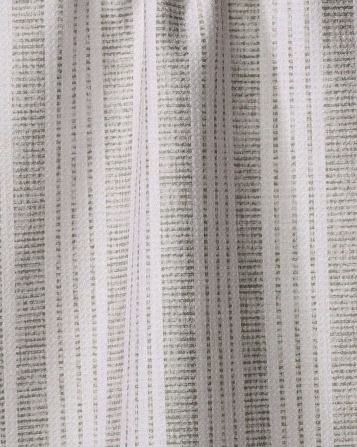Close-up of the Becki Owens Dyer Sage tea towel, showcasing vertical light and dark gray stripes, an ultra-absorbent, slightly wrinkled texture, and soft lighting.