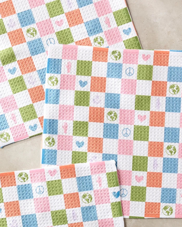 The Kayla Ann Earth Day Checkers kitchen towels feature a colorful pink, green, orange, and blue checkered pattern with heart, peace sign, Earth globe, and hand icons. This vibrant dishcloth set is displayed on a light surface.