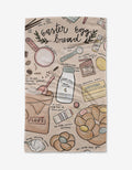 The Easter Egg Bread tea towel by Janna Sue Design features baking tools, flour, butter, eggs, milk, a measuring cup, and braided bread illustrations on ultra-absorbent Geoweave with handwritten recipe notes.