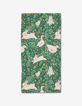 The Easter Meadow bar towel by Janna Sue Design features Geoweave™ fabric with playful white rabbits and ducks, green grass, leafy details, and colorful flowers on a green background with intricate plant motifs.