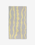 The GEOMETRY Eclipse Twist is a rectangular gray Geoweave textile with ultra-absorbency, featuring evenly spaced wavy vertical yellow stripes, shown laid flat on a white background.