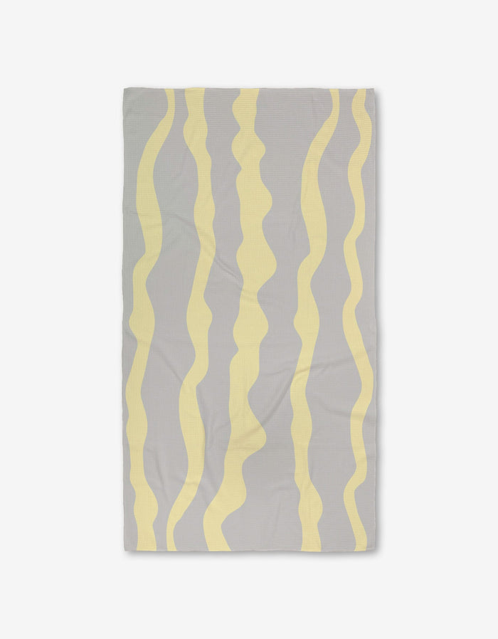 The GEOMETRY Eclipse Twist is a rectangular gray Geoweave textile with ultra-absorbency, featuring evenly spaced wavy vertical yellow stripes, shown laid flat on a white background.