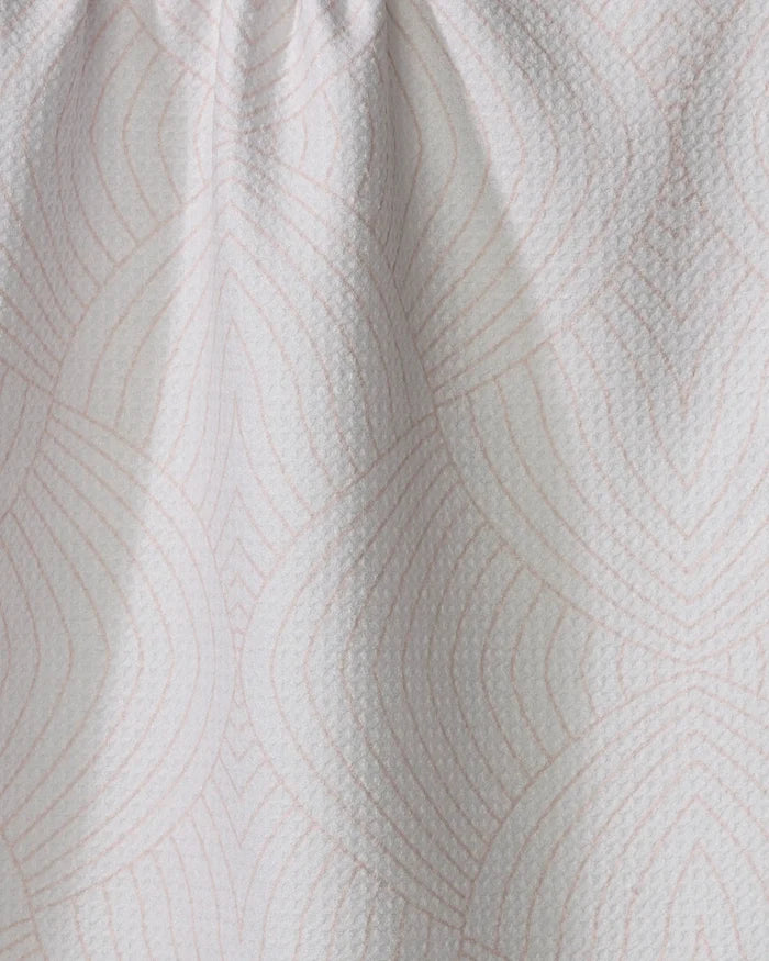 The Eileen tea towel by Amy MacCready is made from recycled materials and features a subtle geometric pattern of overlapping pink lines, with slight gathering at the top for added texture.